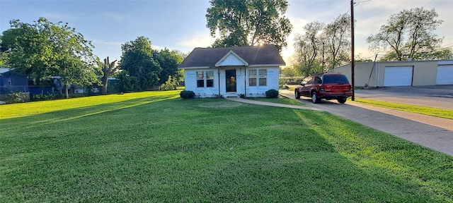 view of front of property featuring a front lawn, an outdoor structure, and a garage