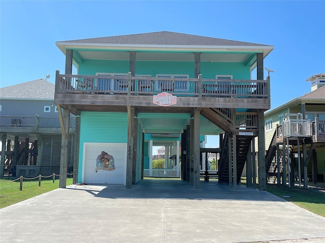 exterior space with driveway, a shingled roof, stairway, an attached garage, and a carport