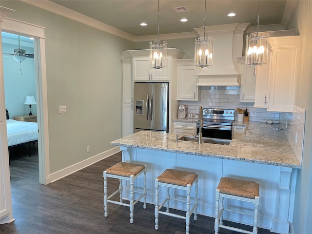 kitchen featuring appliances with stainless steel finishes, pendant lighting, dark wood-type flooring, and backsplash