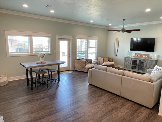 living room featuring crown molding, dark wood-type flooring, ceiling fan, and a textured ceiling