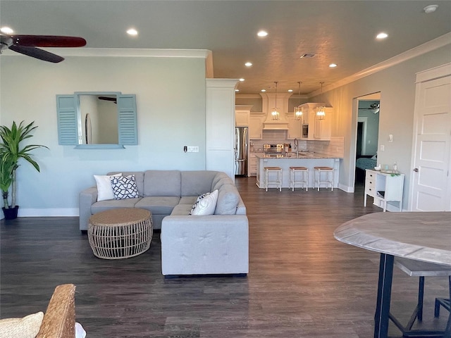 living area featuring recessed lighting, dark wood-style flooring, crown molding, and ceiling fan