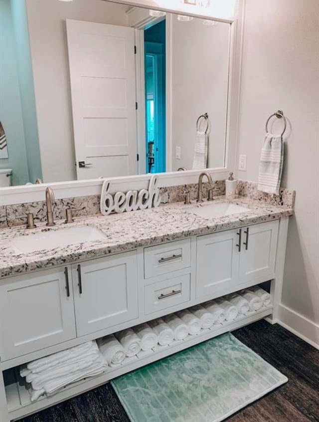 bathroom featuring oversized vanity, hardwood / wood-style flooring, and double sink