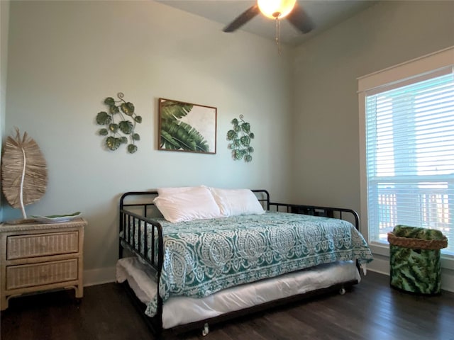 bedroom featuring dark wood-type flooring, a ceiling fan, and baseboards