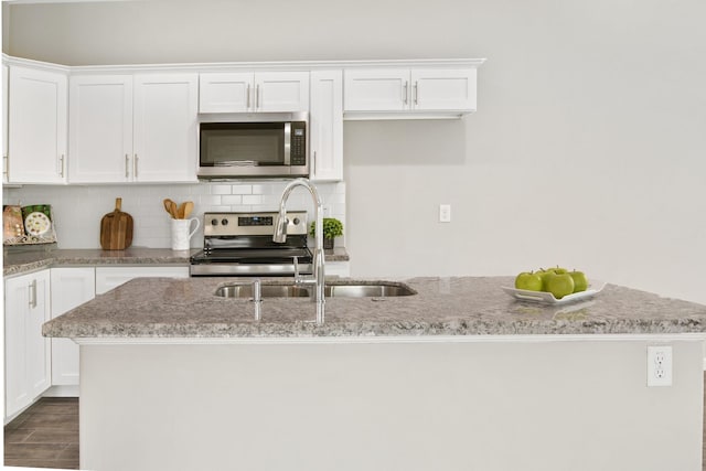 kitchen with white cabinets, a kitchen island, sink, and appliances with stainless steel finishes