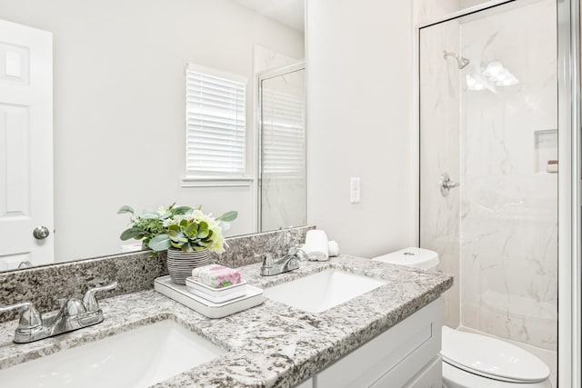 bathroom featuring vanity, a shower with shower door, and toilet