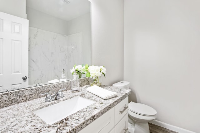 bathroom with hardwood / wood-style floors, vanity, and toilet