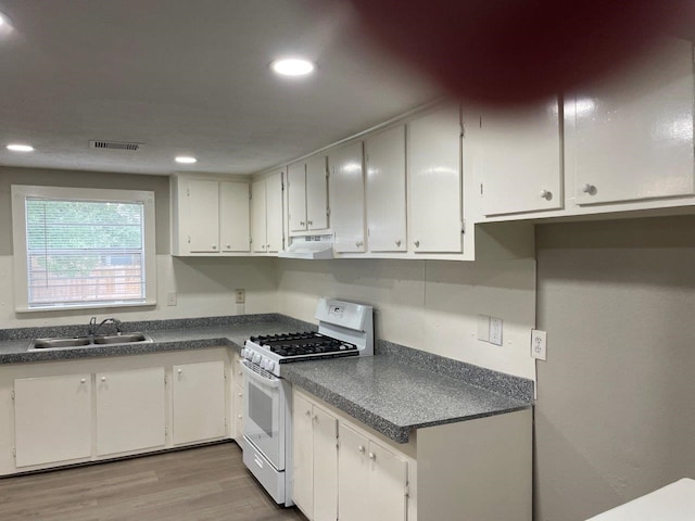 kitchen with range hood, white cabinetry, white range with gas stovetop, and sink