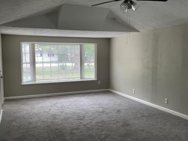 carpeted spare room featuring a textured ceiling, lofted ceiling, ceiling fan, and a wealth of natural light