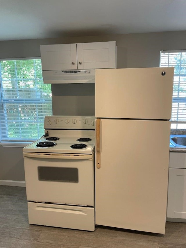 kitchen featuring white appliances and white cabinetry