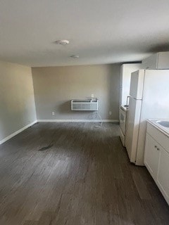 kitchen featuring an AC wall unit, white cabinetry, dark hardwood / wood-style flooring, and white fridge