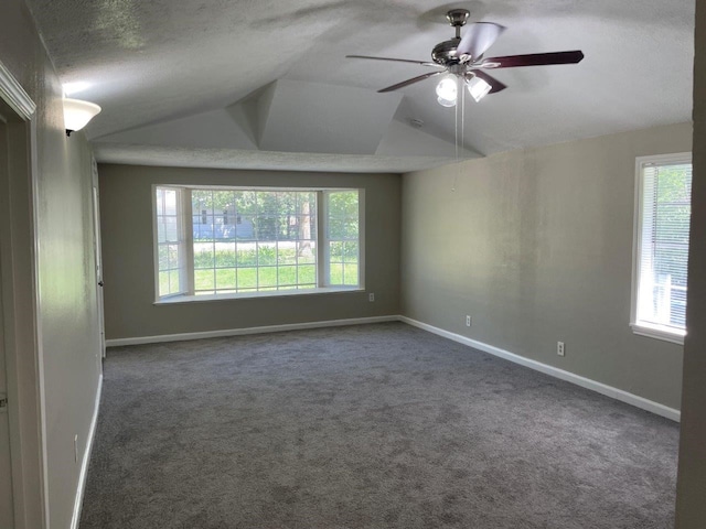 carpeted empty room with a textured ceiling, lofted ceiling, and ceiling fan