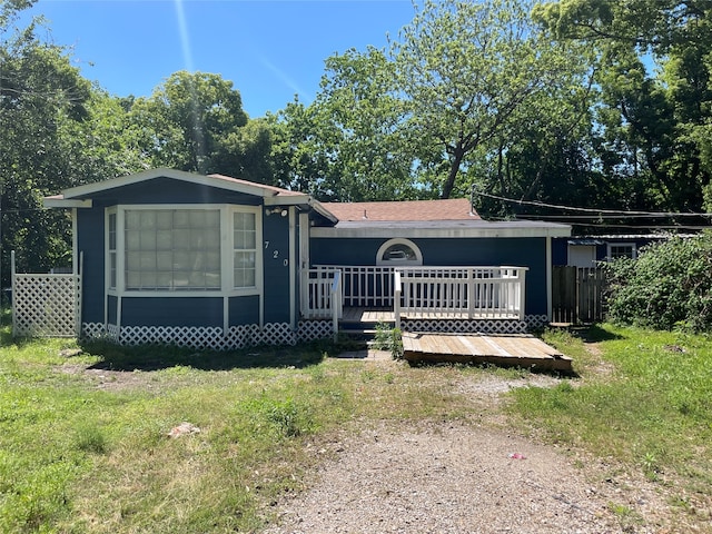 view of front of house featuring a wooden deck and a front lawn