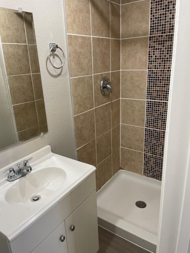 bathroom featuring vanity and tiled shower