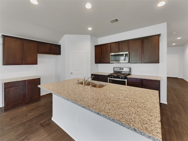 kitchen featuring appliances with stainless steel finishes, dark hardwood / wood-style floors, sink, and an island with sink