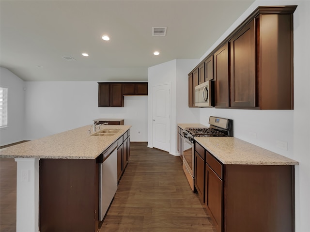 kitchen featuring sink, dark hardwood / wood-style flooring, stainless steel appliances, a kitchen island with sink, and light stone countertops