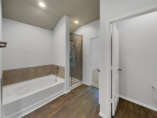 bathroom featuring wood-type flooring, lofted ceiling, and plus walk in shower