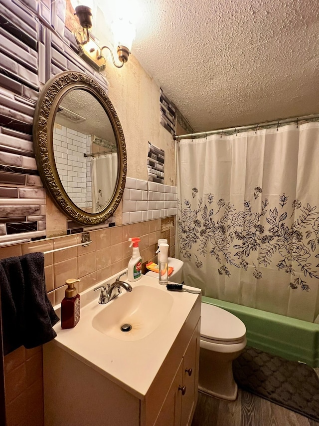 full bathroom with vanity with extensive cabinet space, tile walls, hardwood / wood-style flooring, tasteful backsplash, and toilet