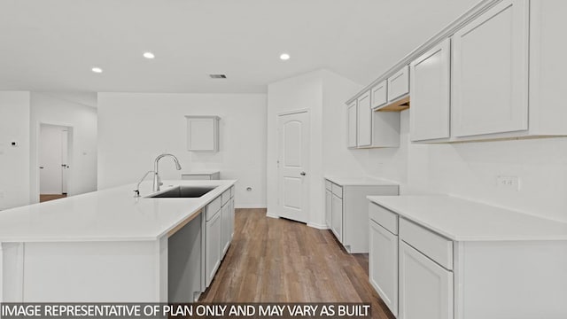 kitchen with light hardwood / wood-style floors, a kitchen island with sink, and sink