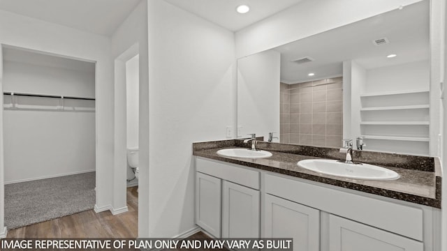 bathroom with hardwood / wood-style floors, vanity, and toilet