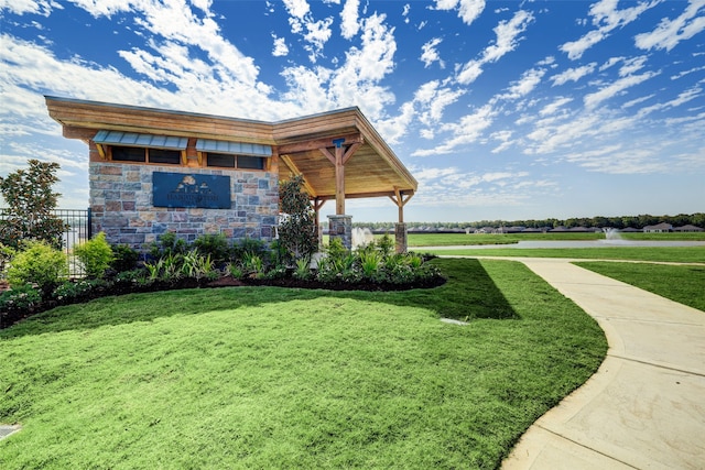 view of community with a yard and a water view