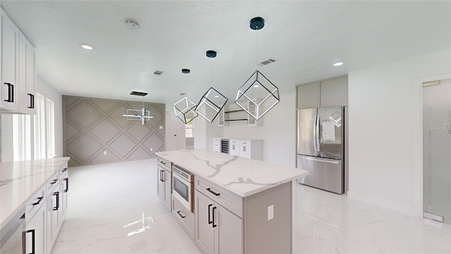 kitchen featuring light stone countertops, stainless steel appliances, decorative light fixtures, a kitchen island, and light tile floors