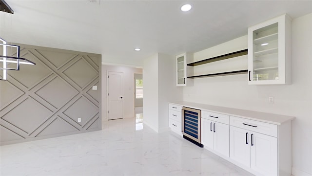 kitchen with wine cooler, white cabinets, and light tile floors