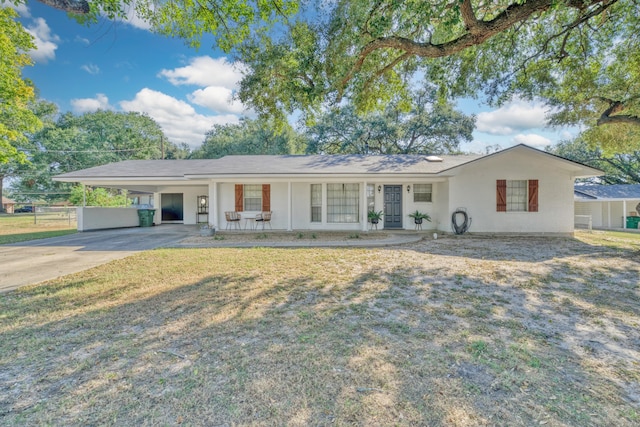 single story home with covered porch, a carport, and a front yard