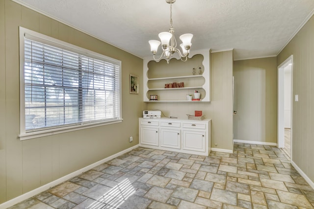 unfurnished dining area with a notable chandelier, ornamental molding, and a textured ceiling