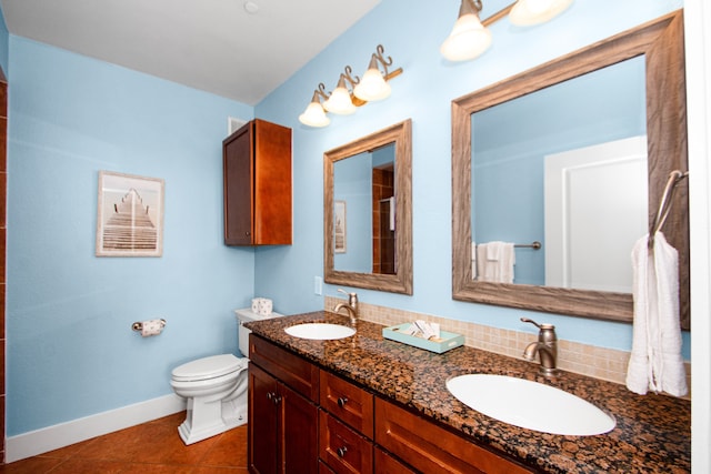 bathroom featuring toilet, dual vanity, and tile flooring