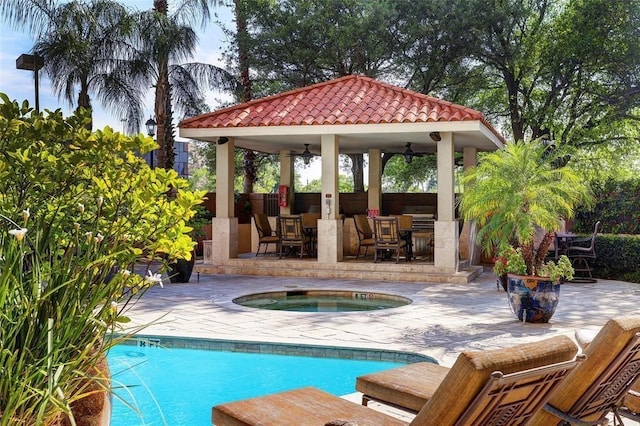 view of pool with a patio, an outdoor bar, an in ground hot tub, and a gazebo