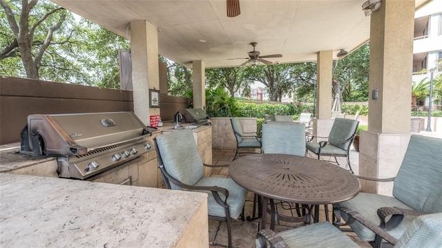 view of patio featuring area for grilling, exterior kitchen, and ceiling fan