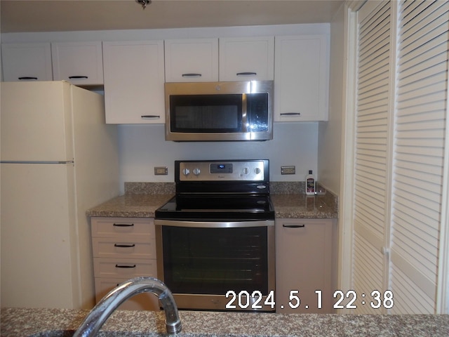 kitchen with white cabinetry, stone counters, and stainless steel appliances