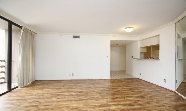 tiled spare room featuring crown molding