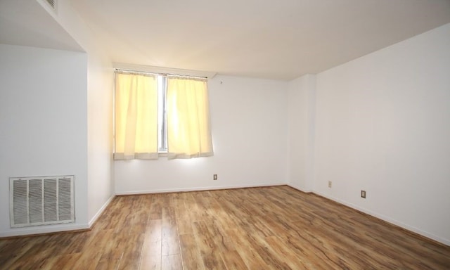 unfurnished room with wood-type flooring