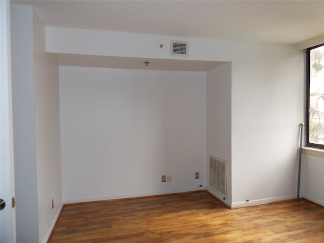 empty room featuring a healthy amount of sunlight and light hardwood / wood-style floors