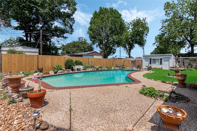 view of pool with an outbuilding and a patio area