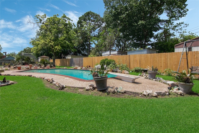 view of swimming pool with a lawn and a diving board