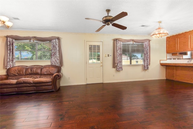 living room with a textured ceiling, ceiling fan with notable chandelier, and dark hardwood / wood-style floors