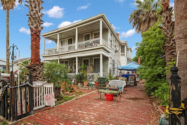 back of house with a porch and a balcony