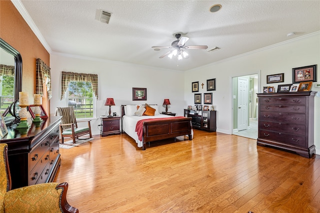 bedroom with light wood-type flooring, ceiling fan, and a textured ceiling