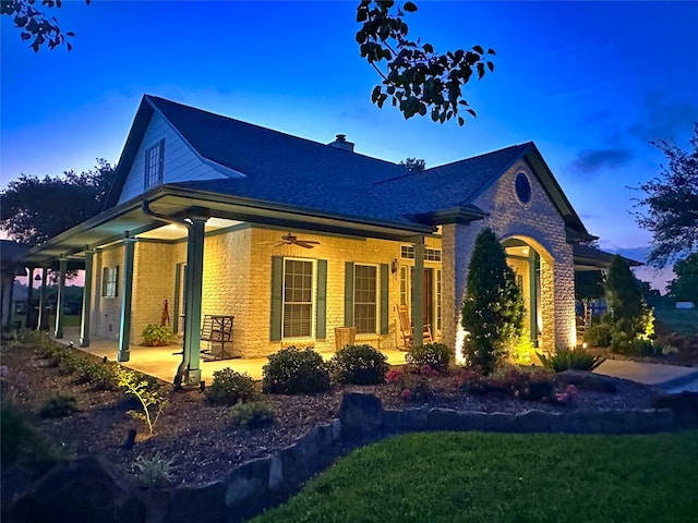 view of front of home with ceiling fan, a lawn, and a patio area