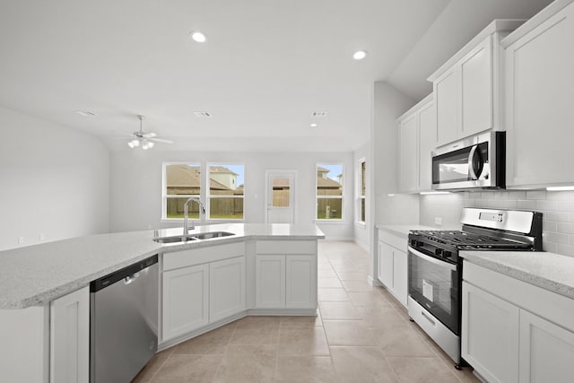 kitchen featuring white cabinetry, sink, ceiling fan, stainless steel appliances, and tasteful backsplash