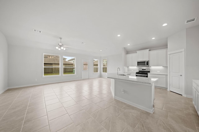 kitchen featuring ceiling fan, sink, a kitchen island with sink, white cabinets, and appliances with stainless steel finishes