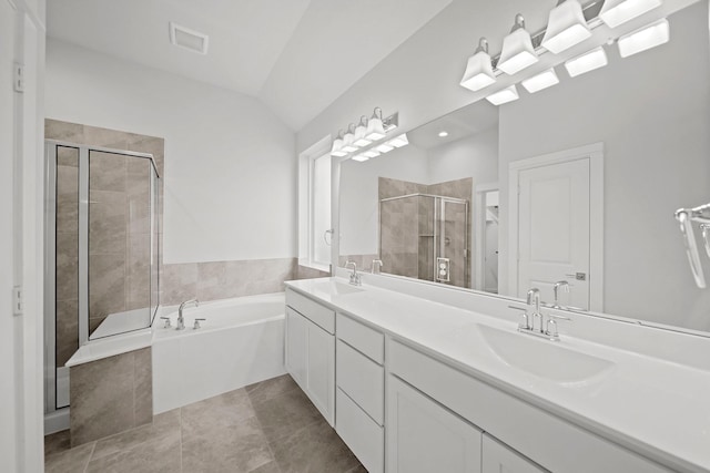 bathroom featuring tile patterned floors, vanity, independent shower and bath, and vaulted ceiling