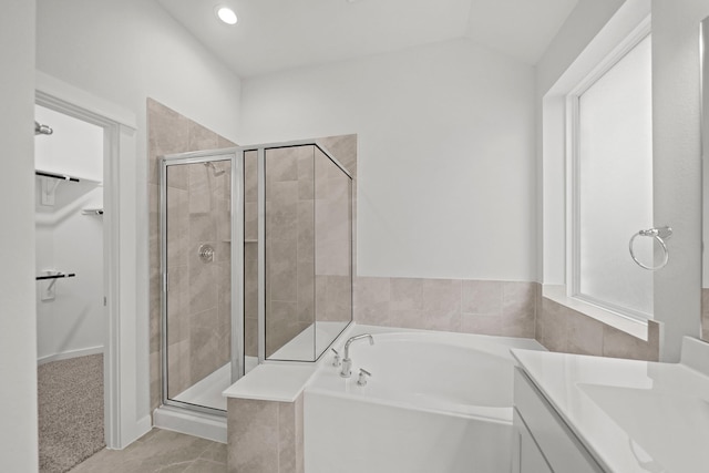 bathroom with vanity, lofted ceiling, and plus walk in shower