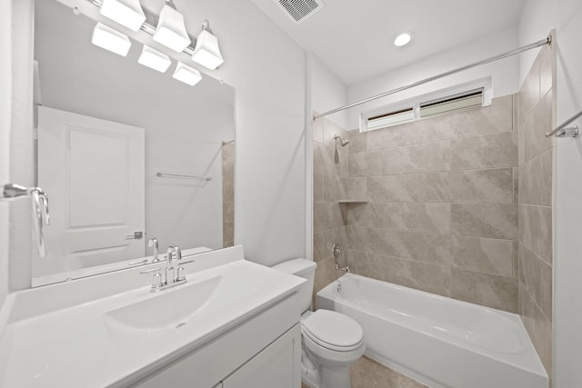 full bathroom featuring vanity, tiled shower / bath combo, and toilet