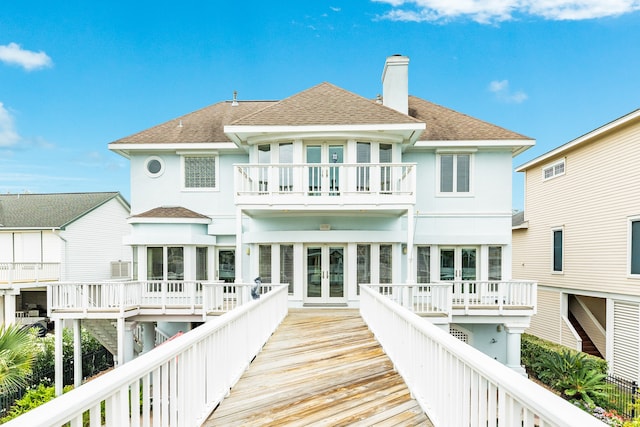 rear view of property featuring a deck and a balcony