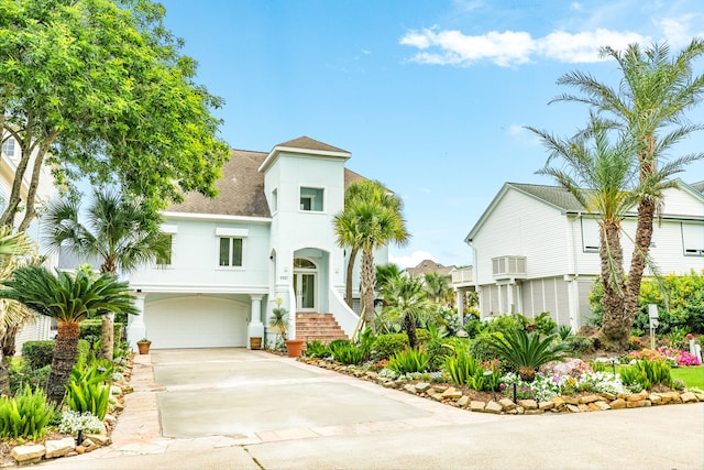 view of front of property featuring a garage and a wall mounted AC