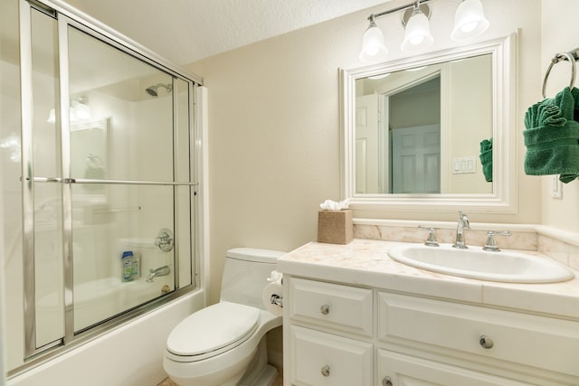 full bathroom with enclosed tub / shower combo, oversized vanity, toilet, and a textured ceiling