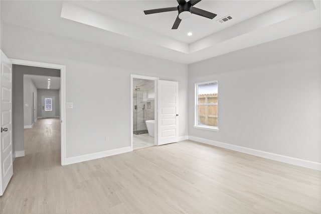 unfurnished bedroom featuring a tray ceiling and light hardwood / wood-style floors